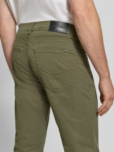 Männermodel trägt Straight Fit Jeans aus elastischem Baumwoll-Mix Modell 'Lyon' von Pierre Cardin, 5 kieszeni, szlufki na pasek, zapięcie na guzik i zamek błyskawiczny, szerokość w rozmiarze 32/34: 41 cm, długość wewnętrzna nogawki: 86 cm, mieszanka bawełny i elastanu, zielony kolor, widoczna faktura materiału, całkowity widok tyłu