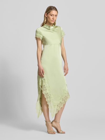 Frauenmodel trägt A-Linie Abendkleid aus Satin Modell 'RITA' von Vero Moda in sanftem Grün mit Spitzen-Details, Ganzkörperansicht von vorne.