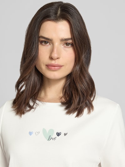 Frauenmodel trägt Relaxed Fit T-Shirt aus reiner Baumwolle von Tom Tailor, Optik: Unifarben, Motiv-Print, Rundhals, Kurzarm, Nahaufnahme Oberkörper.