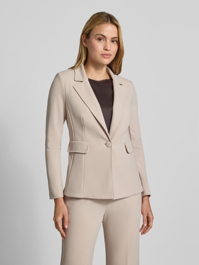 Vrouwenmodel draagt blazer met Reverskraag van Rinascimento in beige, elastische materiaalmix, getailleerde pasvorm, klepzakken, knoopsluiting, ruglengte bij maat S 63 cm, vooraanzicht bovenlichaam.