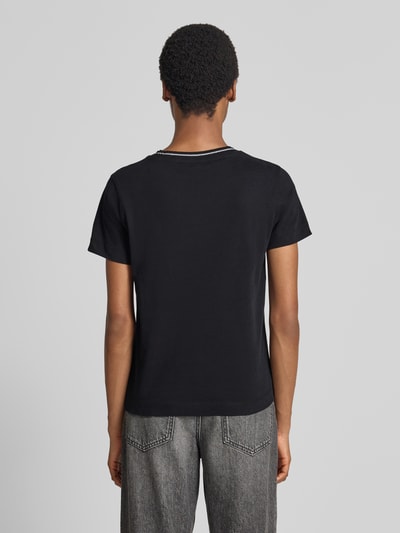 Vrouwenmodel draagt t-shirt uit puur katoen met logodetail van GUESS, getailleerde pasvorm, ronde hals, ruglengte maat S 58 cm, geheel van achteren.
