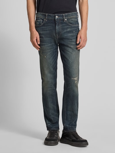 Männermodel trägt Slim Fit Jeans aus Baumwoll-Mix Modell 'DELAWARE BO IMAGE' von BOSS Orange in Used-Look Optik, Unifarben, Ganzkörperansicht von vorne.