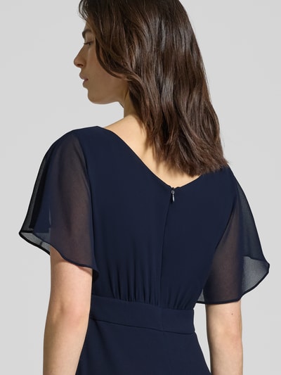 Frauenmodel trägt knielanges Kleid mit Rundhalsausschnitt von Vera Mont in Dunkelblau, semitransparent, Kurzarm, tailliert, Detailaufnahme Rückansicht.