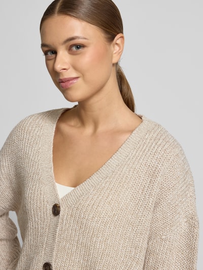Vrouwenmodel draagt Relaxed Fit Strickjacke met V-hals model 'LEA' van Vero Moda in melange optiek, gebreide textuur, detailopname bovenlichaam.