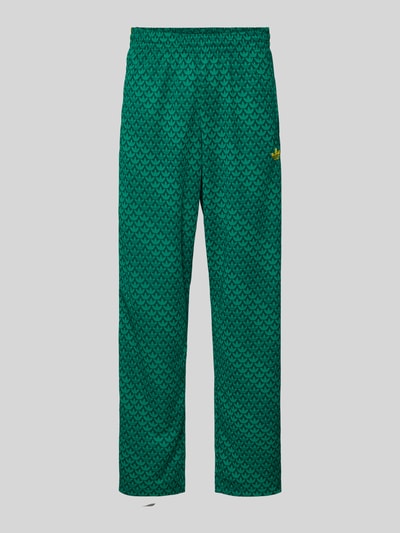 Produktfoto, grüne Sweatpants mit elastischem Bund von adidas Originals, grafisches Muster, lockerer Schnitt, sichtbare Eingrifftaschen