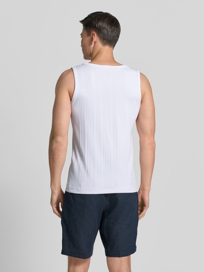 Männermodel trägt Regular Fit Tank Top aus Baumwoll-Mix Modell 'ANDRE' von SELECTED HOMME in Weiß mit gestreifter Struktur, Ganzkörperansicht Rückansicht.