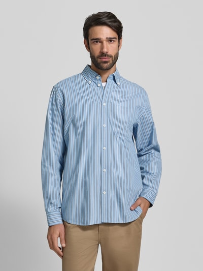 Männermodel trägt Regular Fit Freizeithemd mit Button-Down-Kragen von Les Deux aus reiner Baumwolle mit Streifenmuster, Knopfleiste, Brusttasche, Ganzkörperansicht von vorne.