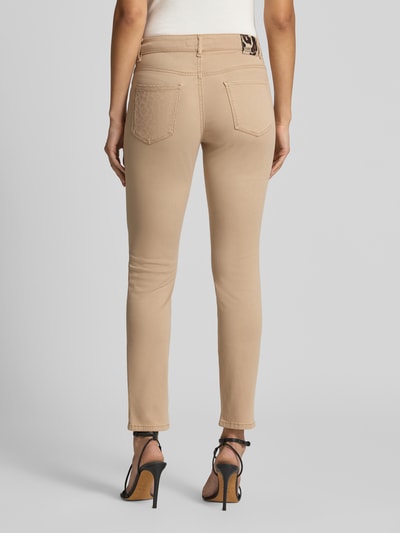 Frauenmodel trägt Flared Fit Jeans mit Lyocell-Anteil von Marc Cain in Beige, 5-Pocket-Design, elastischer Material-Mix, Ganzkörperansicht Rückansicht.