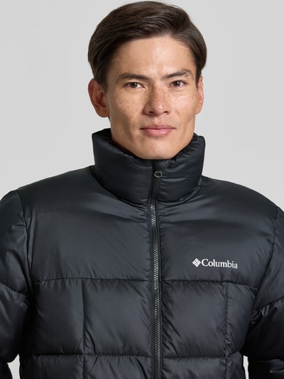 Männermodel trägt Regular Fit Jacke in Stepp-Optik Modell 'Puffect™' von Columbia, schlichte schwarze Textur, Nahaufnahme Oberkörper.