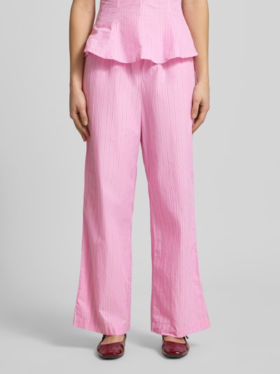 Frauenmodel trägt Wide Fit Pyjama-Hose mit elastischem Bund Modell 'Poplin' von Gina Tricot in Rosa mit weißen Streifen, Nahaufnahme Oberkörper. Elastischer Bund, Tunnelzug, Bundweite S: 36 cm, Innenbeinlänge S: 78 cm.
