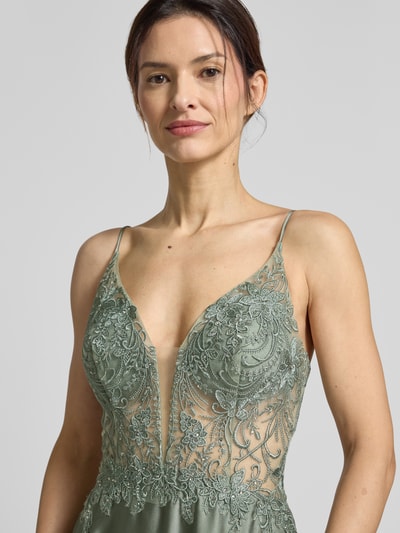 Vrouwenmodel draagt Regular Fit Abendkleid mit floralem Stitching van Laona in semi-transparant groen met florale borduursels en siersteentjes, satijnen stof, spaghettibandjes, zichtbare naadrits, Nahaufnahme bovenlichaam.