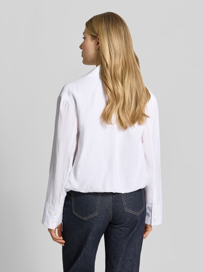 Vrouwenmodel draagt Regular Fit Blouse van viscose met V-hals Model 'DAPHNE' van Samsøe Samsøe, witte stof, recht model, ruglengte 50 cm, mouwlengte 57 cm, van achteren gefotografeerd.