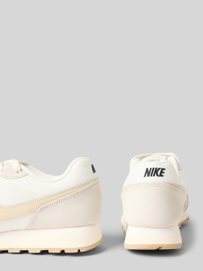 Productfoto, Sneaker met logo-detail model 'Runner' van Nike, afgeronde fit, beige en witte tinten, dames sneaker, detailopname.
