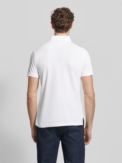 Männermodel draagt Slim Fit Poloshirt met Stretch-Anteil van Tommy Hilfiger, mix van katoen en elastaan, polokraag, korte mouwen, geborduurd logo, ruglengte maat M 69 cm, witte kleur, Ganzkörperansicht Rückansicht.