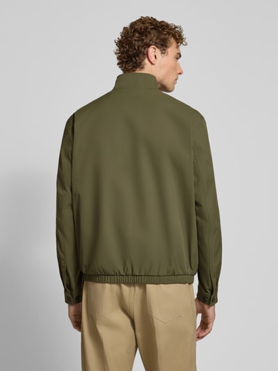 Männermodel trägt Regular Fit Blouson mit Stehkragen Modell 'Carvo' von BOSS in Olivgrün, Herren Bomberjacke, Ganzkörperansicht Rückansicht.