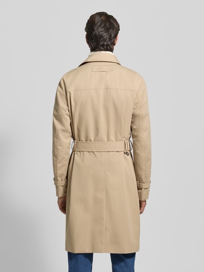 Männermodel draagt Regular Fit Trenchcoat met Gun Flap model 'MALUKS2511' van HUGO, look: effen, loopsplit, achterpas, tailleriem, lange mouwen, waterafstotend, zij-steekzakken, binnenzak, beige tint, Ganzkörperansicht Rückansicht.