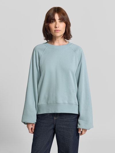 Frauenmodel trägt Oversized Sweatshirt mit Rundhalsausschnitt von Closed aus reiner Baumwolle in Hellblau, Ballonärmel, Ganzkörperansicht von vorne.