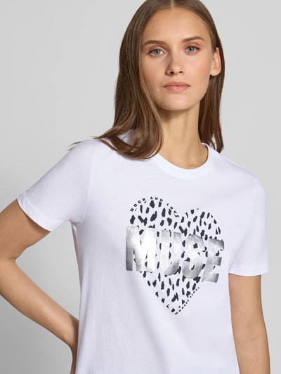 Frauenmodel trägt Regular Fit T-Shirt aus reiner Baumwolle Modell 'KITA' von ONLY in Weiß mit silbernem Herzprint, Nahaufnahme Oberkörper, Damen T-Shirt von ONLY.