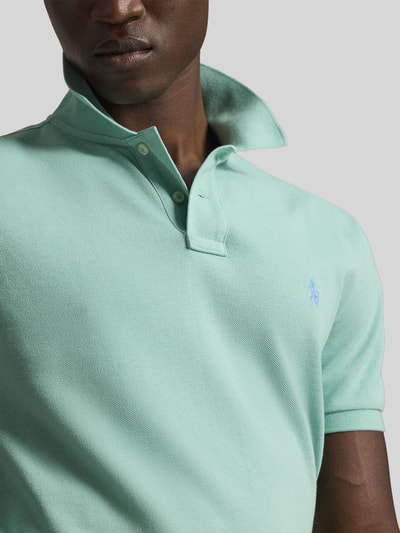 Männermodel trägt Regular Fit Poloshirt aus reiner Baumwolle von Polo Ralph Lauren in Mintgrün, Piqué-Struktur, Nahaufnahme Oberkörper.