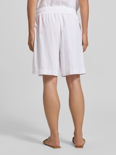 Frauenmodel trägt weiße Leinenshorts mit elastischem Bund und Kordelzug, Leinen-Mix mit Viskose-Anteil, Modell 'Lava' von FREE/QUENT, Loose-Fit, französische Eingrifftaschen, Bundweite 39 cm, Innenbeinlänge 50 cm, Ganzkörperansicht Rückansicht.