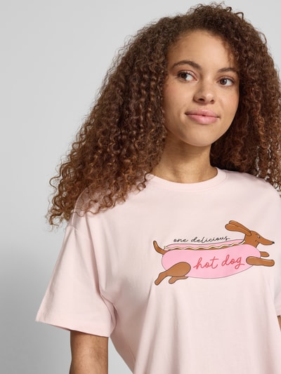 Frauenmodel trägt Regular Fit T-Shirt aus reiner Baumwolle Modell 'VIVVI' von Only, Optik: Unifarben, Motiv-Print, Rundhals, Kurzarm, Materialverarbeitung: Jersey, Material: Baumwolle-Mix mit weicher Textur in zarten Pastellfarben, Nahaufnahme Oberkörper.