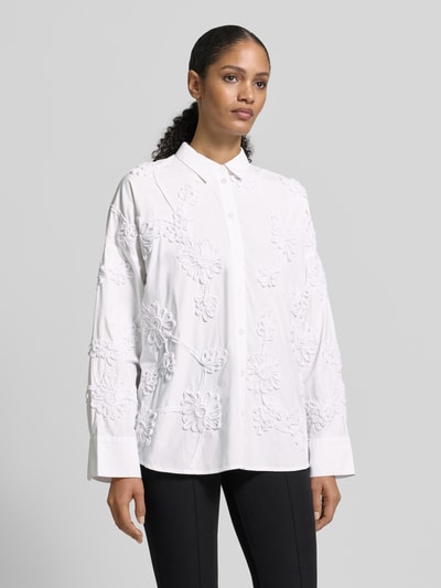 Kobiece modelka nosi Relaxed Fit Hemdbluse floralem Allover-Besatz od Jake*s Collection, z kołnierzykiem koszulowym, krój relaxed fit, kwiatowy wzór na całej powierzchni, listwa guzikowa, sportowe mankiety, długość tyłu 70 cm, długość rękawów 50 cm, białe odcienie, proste kształty, tekstura z ozdobnym obszyciem, widok całej sylwetki z przodu.