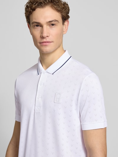 Männermodel trägt Regular Fit Sport Poloshirt mit Kontraststreifen von Lacoste Sport in Weiß, Kurzarm, dezente Musterstruktur, Nahaufnahme Oberkörper.