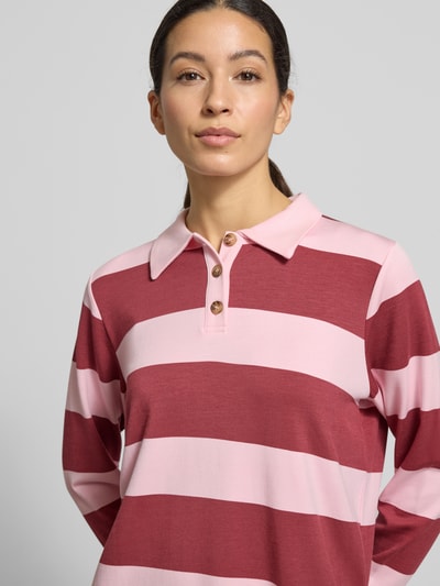 Frauenmodel trägt Sweatshirt mit Polokragen Modell 'BARNI' von Soyaconcept mit breiten rosa und bordeaux Streifen, Nahaufnahme Oberkörper.