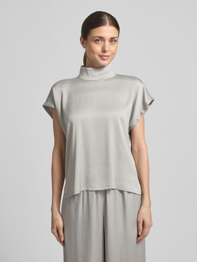 Kobiece modelka nosi Blusenshirt mit Stehkragen Modell 'ALARIA' von Drykorn, mieszanka materiałów z dodatkiem streczu, krój regular fit, długość tyłu w rozmiarze 36: 59 cm, jasnoszary kolor, proste linie, gładka tekstura, Ganzkörperansicht von vorne.