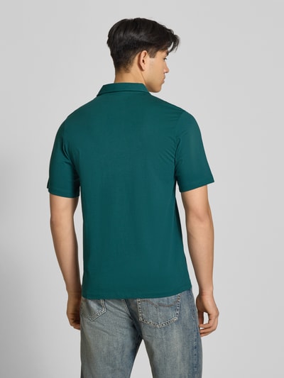 Männermodel trägt poloshirt met labelprint model 'BRANDON' van Jack & Jones van puur katoen in regular fit, ruglengte maat M 71 cm, ganzkörperaanzicht achteraan