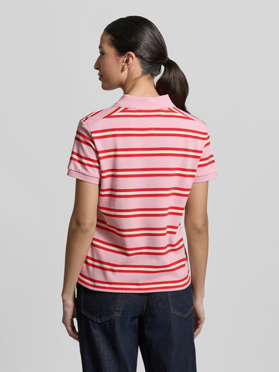 Frauenmodel trägt Regular Fit Poloshirt aus Baumwoll-Mix von Tommy Hilfiger, Optik:Unifarben, Muster: Gestreift, Kurzarm, Logo-Detail, Materialverarbeitung: Piqué, Rumpfabschluss: Tunnelzug, Ganzkörperansicht Rückansicht.