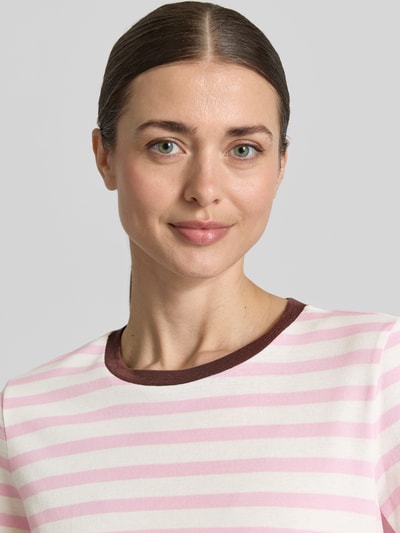 Kobiece modelka nosi T-Shirt mit Streifenmuster und Rundhalsausschnitt von Jake*s Casual z czystej bawełny, krój regular fit, różowo-białe paski, okrągły dekolt, długość tyłu w rozmiarze S: 58 cm, zbliżenie na górną część ciała.