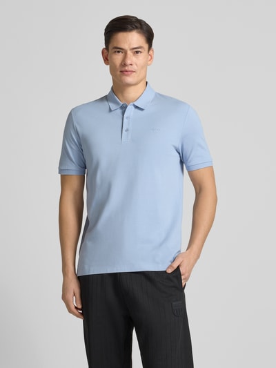 Männermodel trägt Regular Fit Poloshirt aus reiner Baumwolle Modell 'DONOS222' von HUGO, hellblau, unifarben, Ganzkörperansicht von vorne.