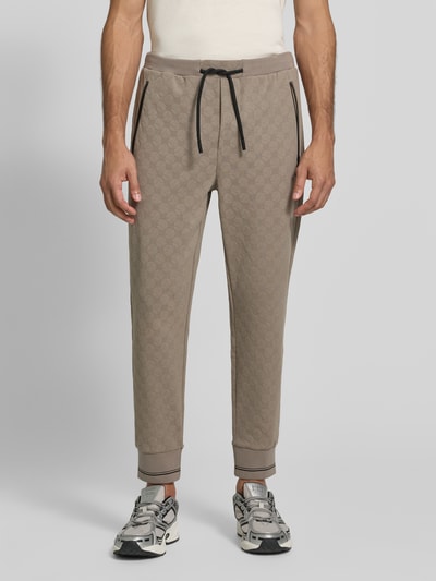 Männermodel trägt Regular Fit Sweathose aus Baumwoll-Mix Modell 'JT_Revival Hover' von BOSS, beige mit Rautenstruktur, Ganzkörperansicht von vorne, Herren Sweathose von BOSS.