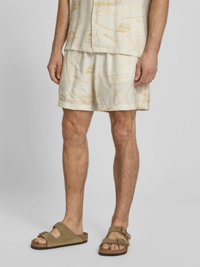 Männermodel trägt Shorts aus Viskose-Mix von MAISON KITSUNÉ in Beige mit elastischem Bund, Eingrifftaschen und Crinkle-Optik, Nahaufnahme Unterkörper, gerade Passform