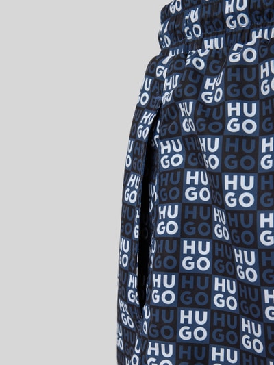 Produktfoto, Regular Fit Badeshorts mit Label-Prägung Modell 'AARON' von HUGO, Optik: Unifarben, Passform: Regular-Fit, Applikation: Label-Print, Bundabschluss: Elastisch mit Tunnelzug, Taschen: Seitliche Eingrifftaschen, blaue und weiße Farbflächen, glatte Textur