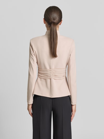 Frauenmodel trägt Jacke mit kurzem Reißverschluss von Rinascimento in Beige, taillierter Schnitt, Drapierungen, Material-Mix, Ganzkörperansicht Rückansicht.