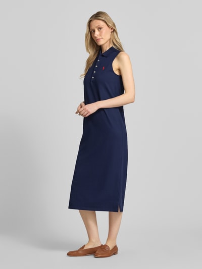Frauenmodel trägt Figurumschmeichelndes Polokleid aus Baumwoll-Mix von Polo Ralph Lauren in Optik: Unifarben, Midi-Länge, Piqué-Struktur, Logo-Stitching, Seitenschlitz, Ganzkörperansicht von vorne.