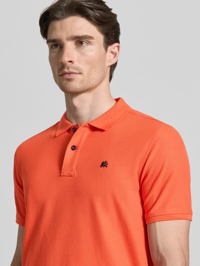 Männermodel trägt Poloshirt mit Logo-Stitching Modell 'PERFORMANCE' von Lerros in Orange, Baumwoll-Mix, Regular-Fit, Nahaufnahme Oberkörper. Rückenlänge bei Größe M: 73 cm, Polokragen und kurze Knopfleiste.