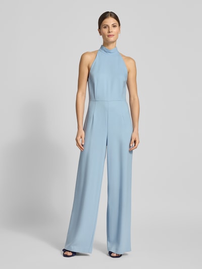 Frauenmodel trägt taillierten, hellblauen Jumpsuit mit Neckholder-Oberteil von SIC curated by Vicky Heiler, ausgestelltes Bein, Ganzkörperansicht von vorne