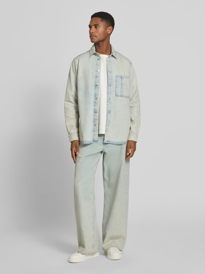 Männermodel trägt Regular Fit Jeanshemd mit Brusttasche Modell 'DAMON' von Samsøe Samsøe aus Reine Baumwolle, Ganzkörperansicht von vorne.