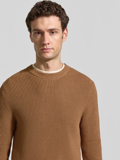 Männermodel trägt Regular Fit Strickpullover aus reiner Baumwolle von MCNEAL in Braun mit Rundhalsausschnitt, Nahaufnahme Oberkörper.