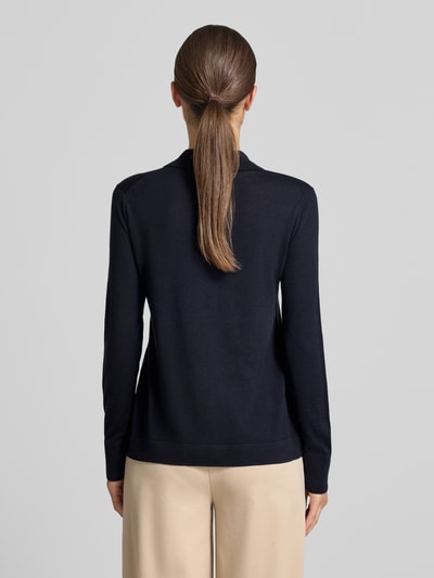 Frauenmodel trägt Strickjacke aus reiner Schurwolle Modell 'DETTO' von MM by Max Mara in Dunkelblau, glatte Textur, Ganzkörperansicht Rückansicht.