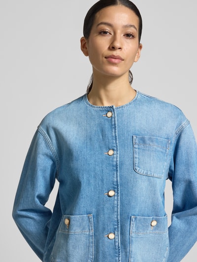 Frauenmodel trägt Jeansjacke mit Rundhalsausschnitt Modell 'Paris' von Brax aus Baumwoll-Elasthan-Mix, Regular-Fit, helle Waschung, aufgesetzte Taschen, Knopfleiste, Nahaufnahme Oberkörper.