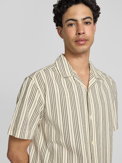 Männermodel trägt Relaxed Fit Freizeithemd aus reiner Baumwolle Modell 'CRUZ' von Only & Sons, gestreiftes Seersucker-Material, Nahaufnahme Oberkörper.