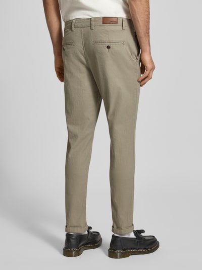 Männermodel trägt Straight Fit Stoffhose aus Baumwoll-Mix Modell 'MARCO FURY' von JACK & JONES in Beige mit Gesäßtaschen, Ganzkörperansicht Rückansicht. Kontext: Herren Stoffhose, Baumwoll-Elasthan-Mix, Straight Fit, Knopf- und Reißverschluss, Bundweite 44 cm, Innenbeinlänge 77 cm.