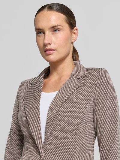 Kobiece model prezentuje żakiet z elastycznej mieszanki materiałów z dodatkiem wiskozy ICHI, fakturowany wzór, model 'Kate', kołnierz z połami, kieszenie z wypustkami, zapięcie na guzik, taliowany krój, zbliżenie na górną część ciała.