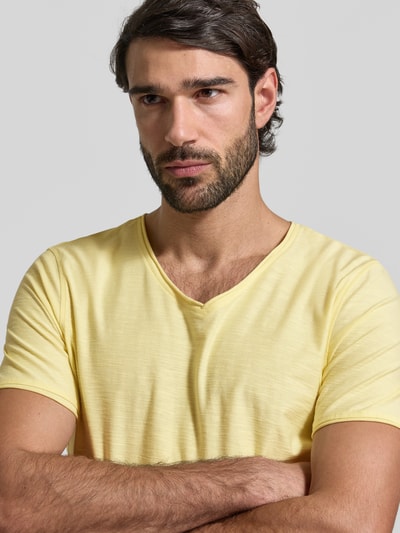 Męski model nosi T-shirt mit geripptem Rundhalsausschnitt von MCNEAL, kolor żółty, krój regular fit, długość tyłu w rozmiarze M: 65 cm, zbliżenie na górną część ciała