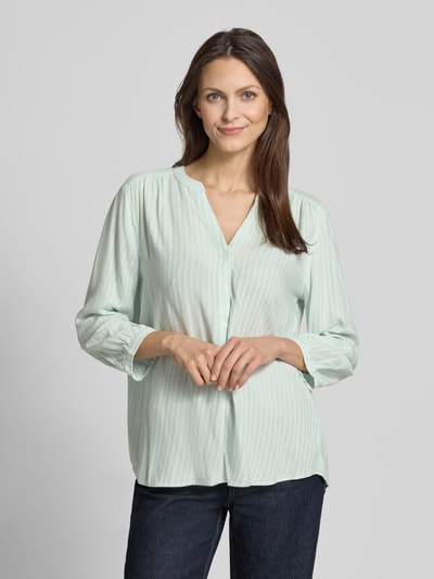 Frauenmodel trägt Comfort Fit Langarmbluse aus reiner Viskose von Tom Tailor mit Allover-Muster, Mao-Kragen und 3/4-Arm, Nahaufnahme Oberkörper.