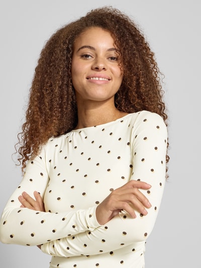 Vrouwenmodel draagt Longsleeve met Label-Stitching model 'Maeve' van OH APRIL in crèmekleur met zwarte stippen, slim fit, Nahaufnahme Oberkörper.